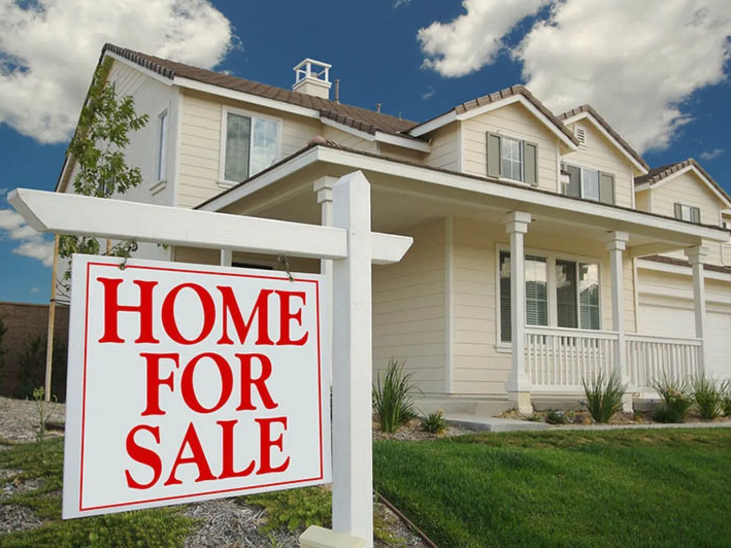 A house with a home for sale sign in front of it